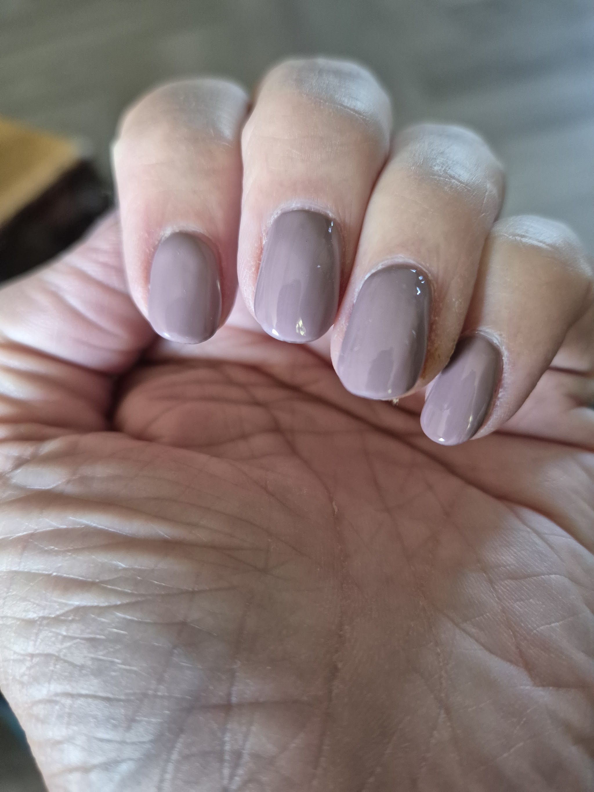 Naturelle nagels in taupe op een open hand